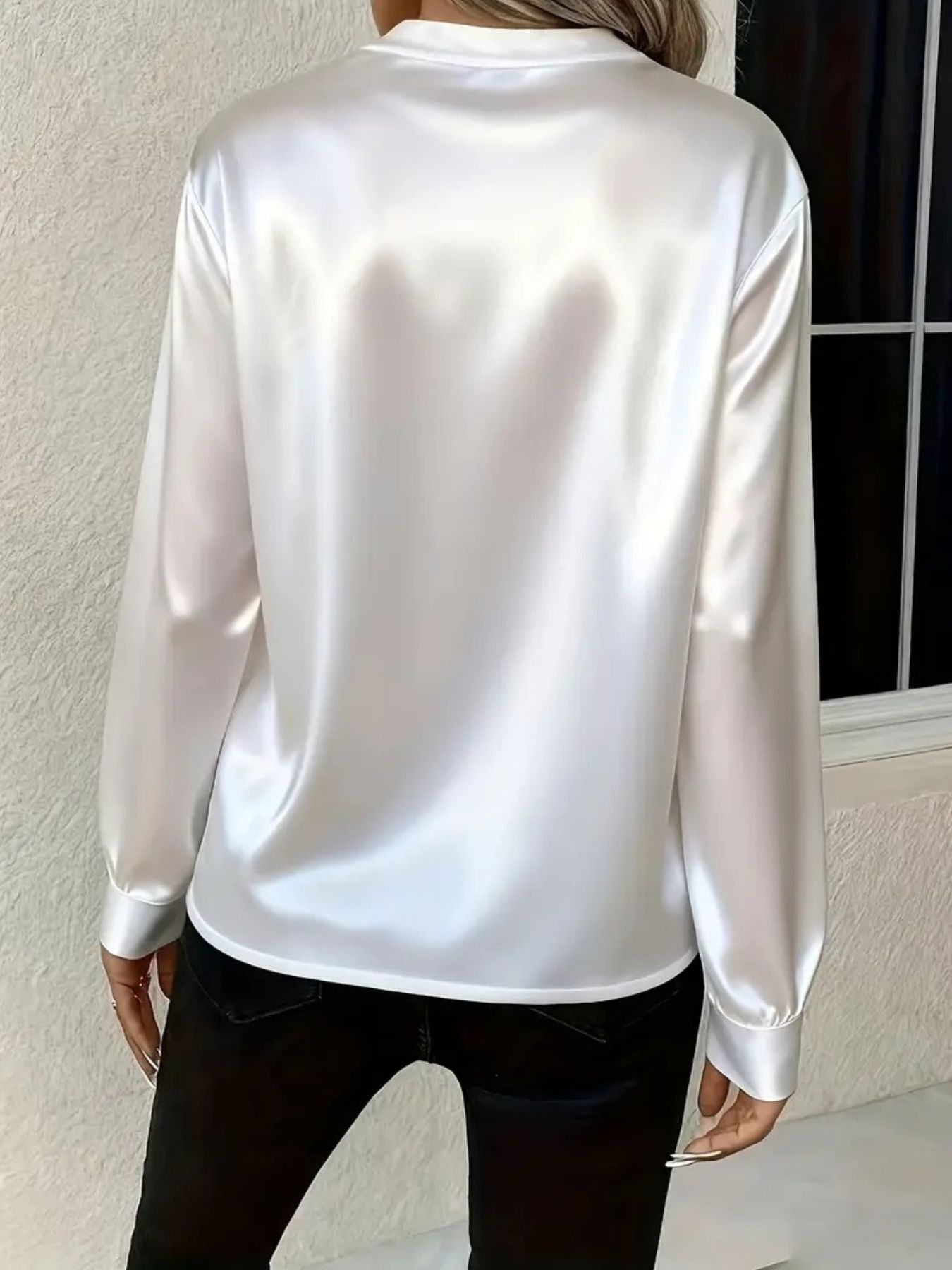 White satin long sleeve blouse with a notched neckline, shown from the back.