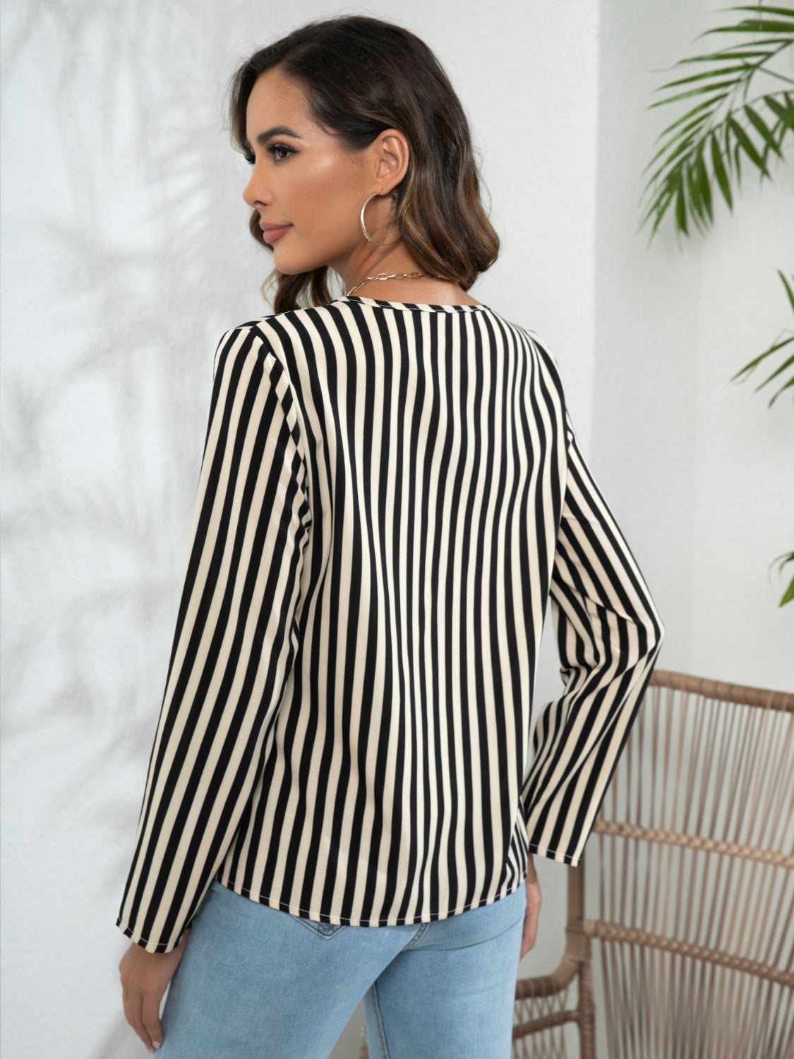 White and tan vertical stripe blouse with long sleeves and a keyhole neckline.