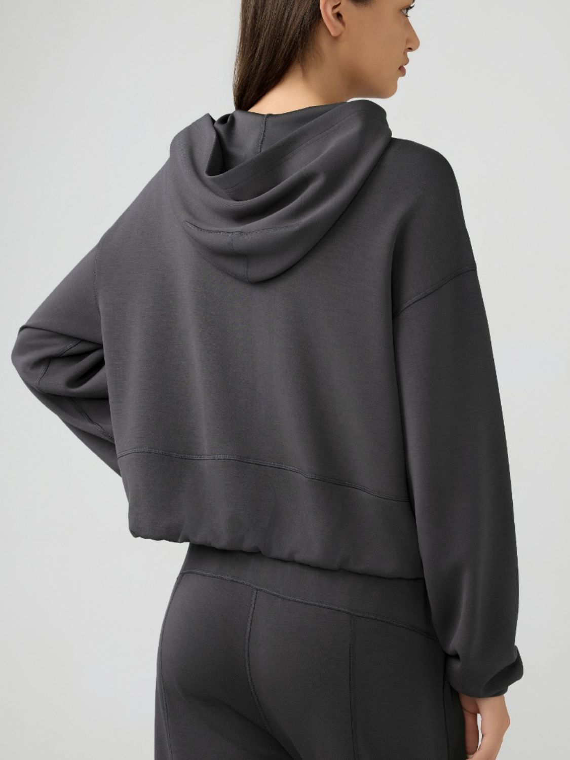 Cropped active hoodie in dark gray with raglan sleeves and a relaxed fit.