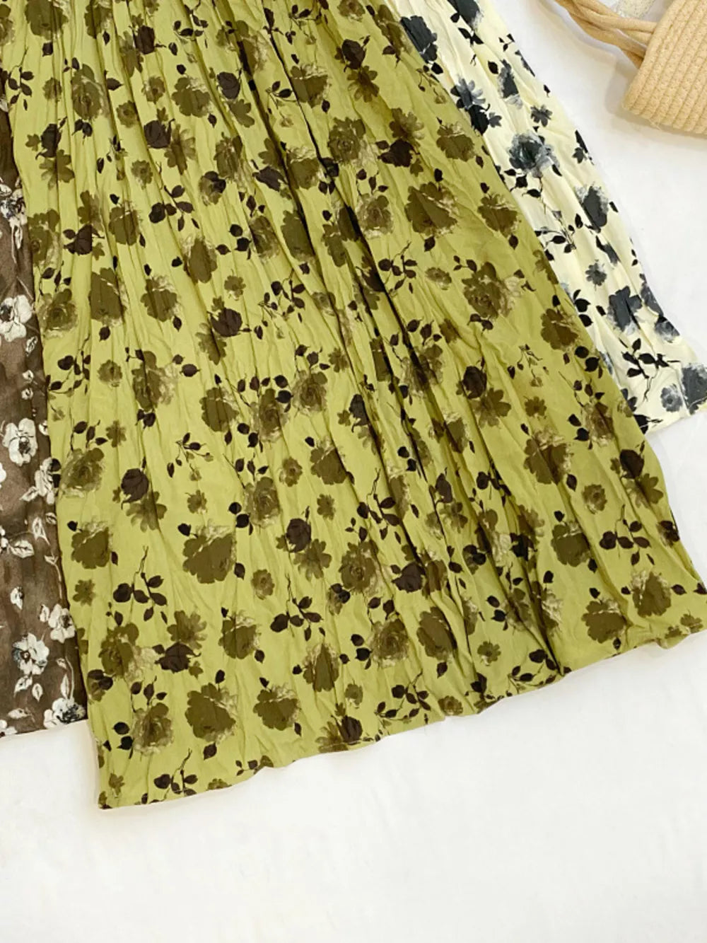Botanical pleated midi skirt in olive with crinkled texture and floral print.