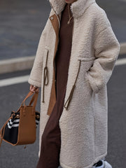 Oversized beige sherpa coat with suede accents and drawstring details.