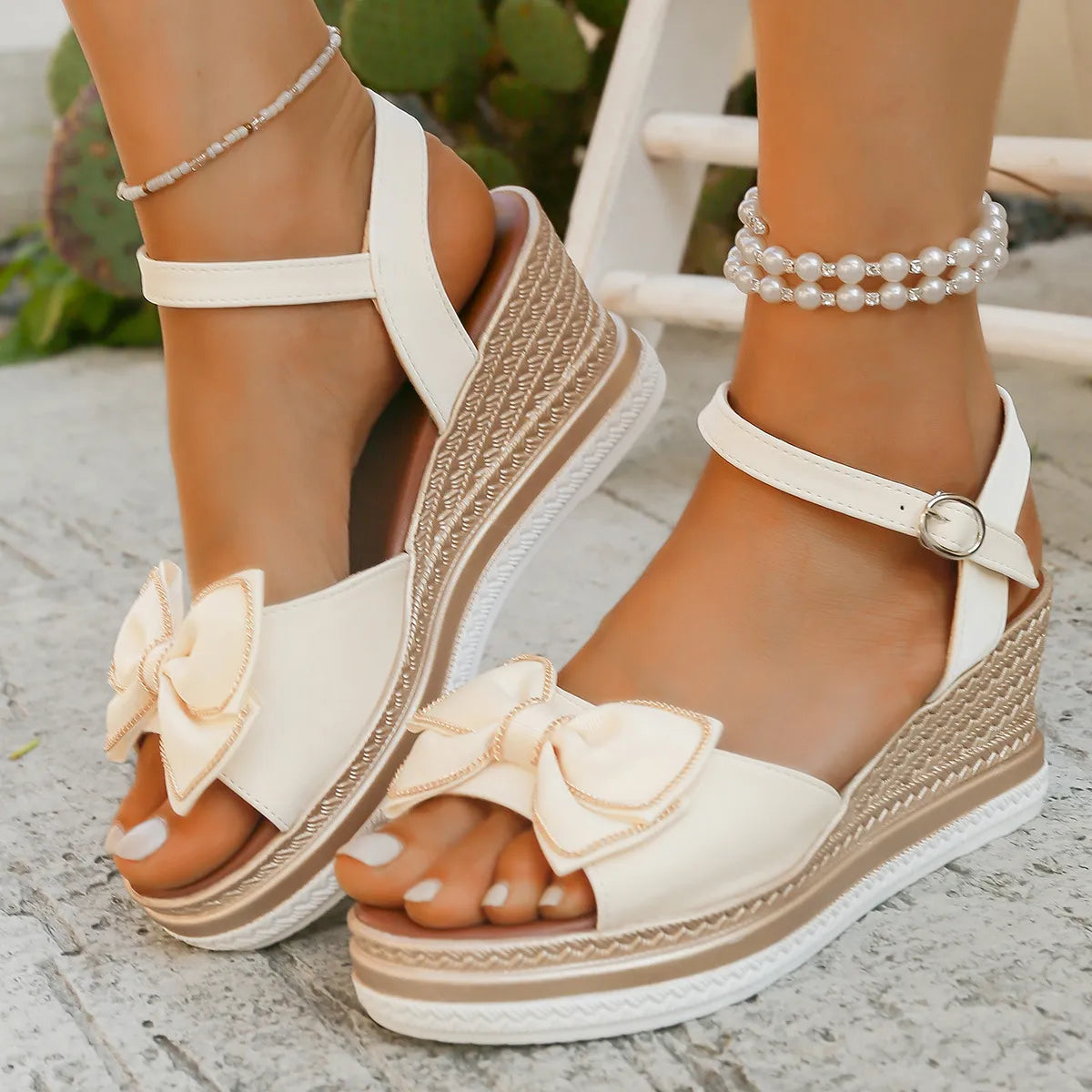 Ivory espadrille wedge sandals with bow detail and ankle strap.