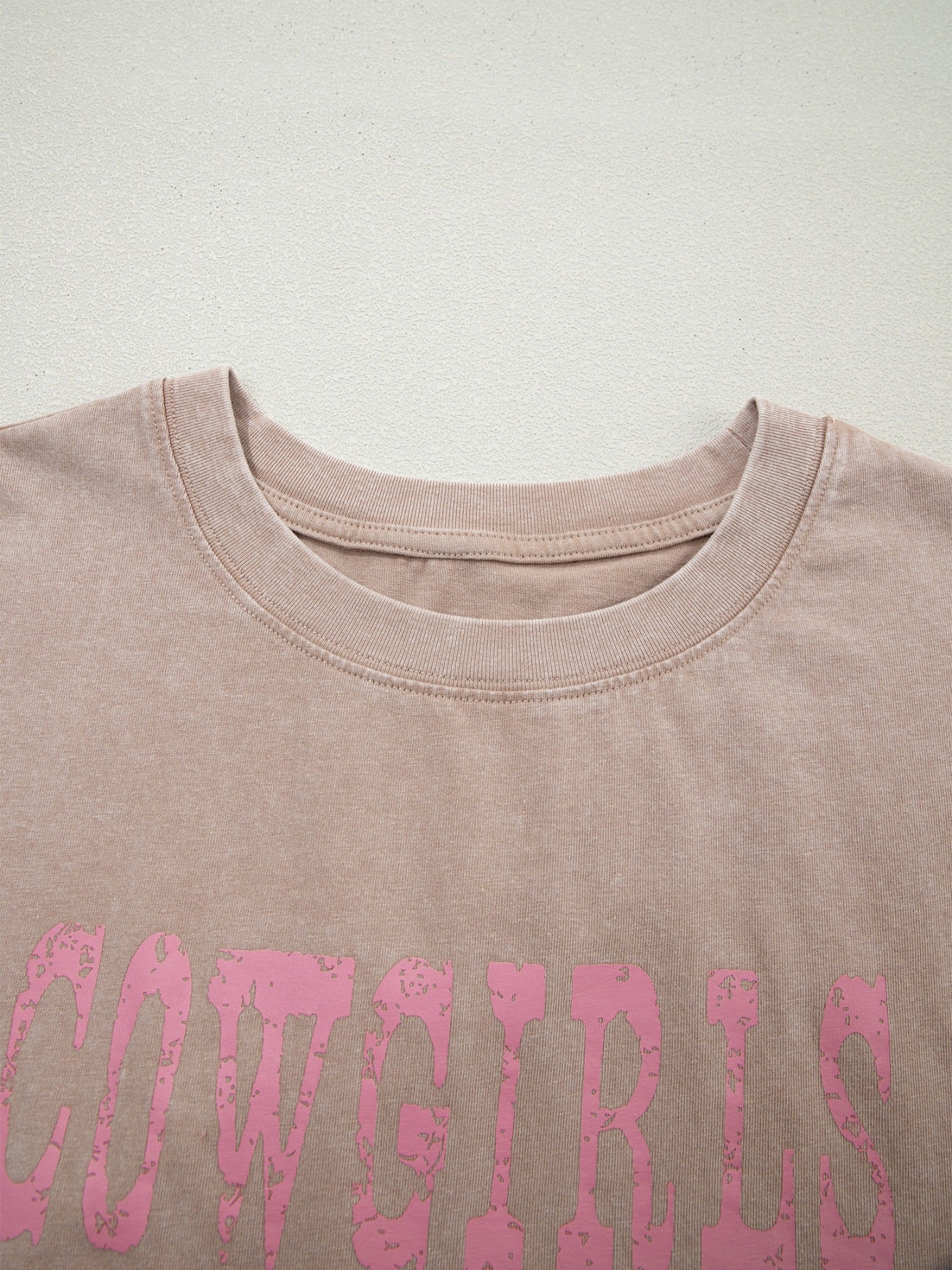Acid-washed cotton tank top in Khaki with distressed pink "COWGIRLS" graphic.
