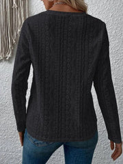 Black geometric eyelet long sleeve knit top with a textured pattern.