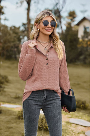 Dusty pink textured knit polo shirt with button neckline and long sleeves.