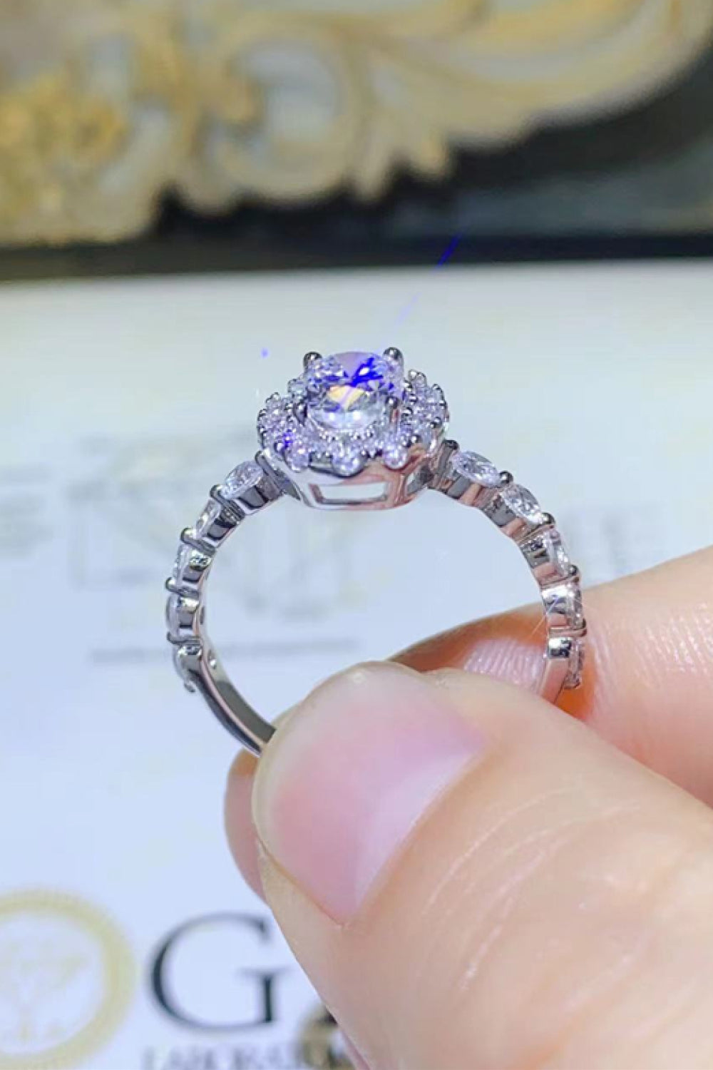White oval moissanite halo ring with diamond accents on band