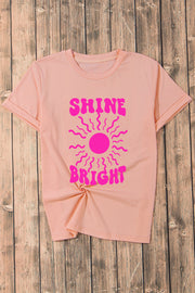 Watermelon pink t-shirt with a retro sunburst graphic and "Shine Bright" text.