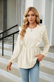 Ivory textured ruffle peplum blouse with long sleeves and a round neckline.