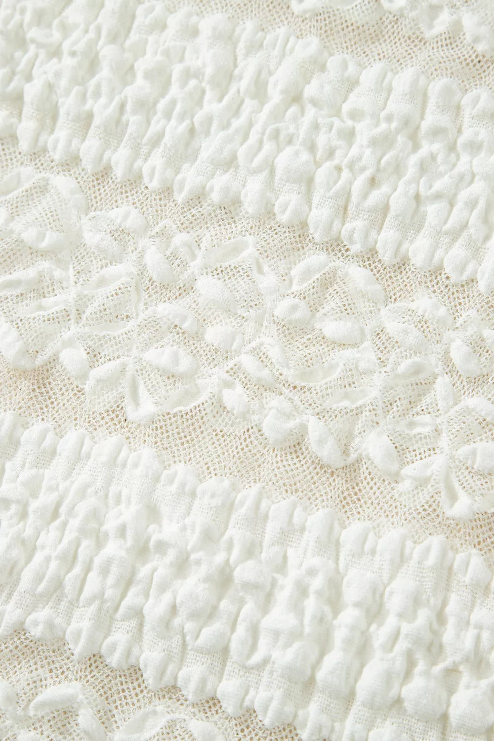 White lace patchwork sheer t-shirt with textured fabric and floral details.