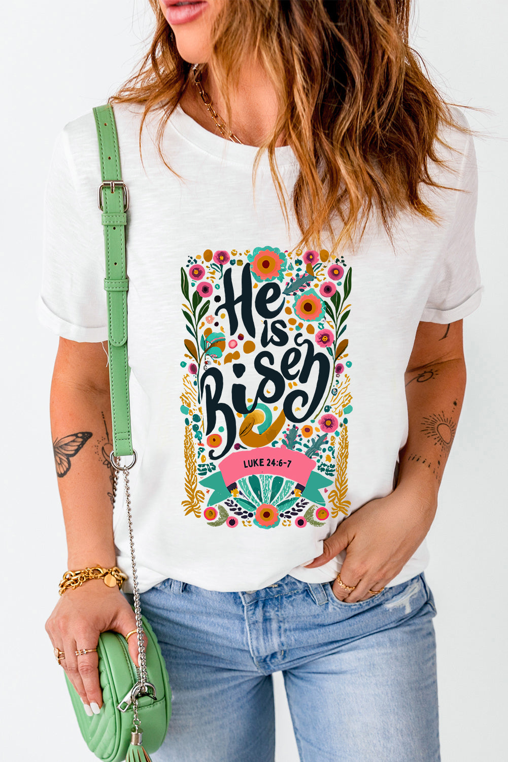 White t-shirt with embroidered floral verse "He is Risen" and Luke 24:6-7 scripture.