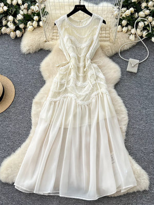 Tiered lace midi maternity dress in white with bow detail and sheer overlay.