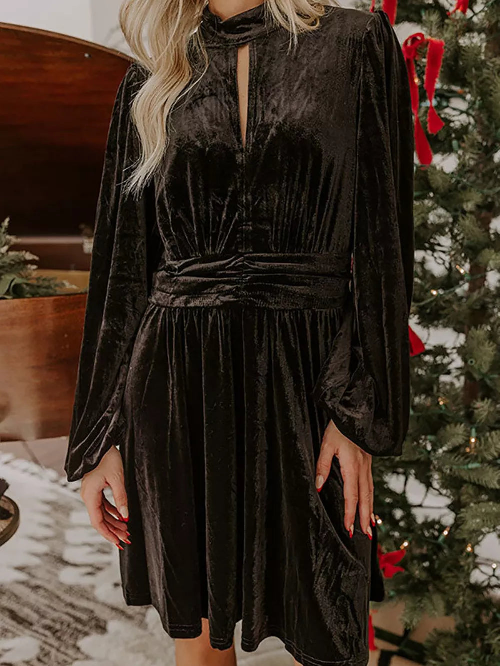 Black velvet mock neck dress with balloon sleeves and cinched waist detail.