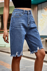 Medium wash denim bermuda shorts with frayed hem and distressed details.