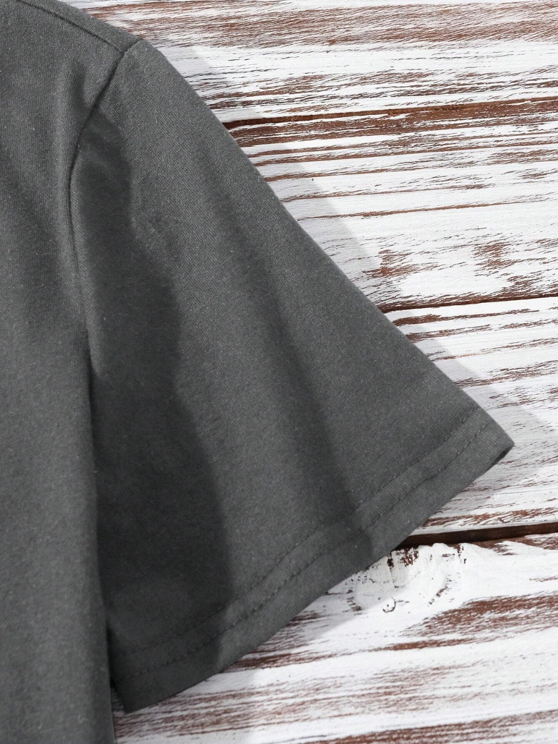 Dark gray short sleeve t-shirt with a shamrock graphic detail.