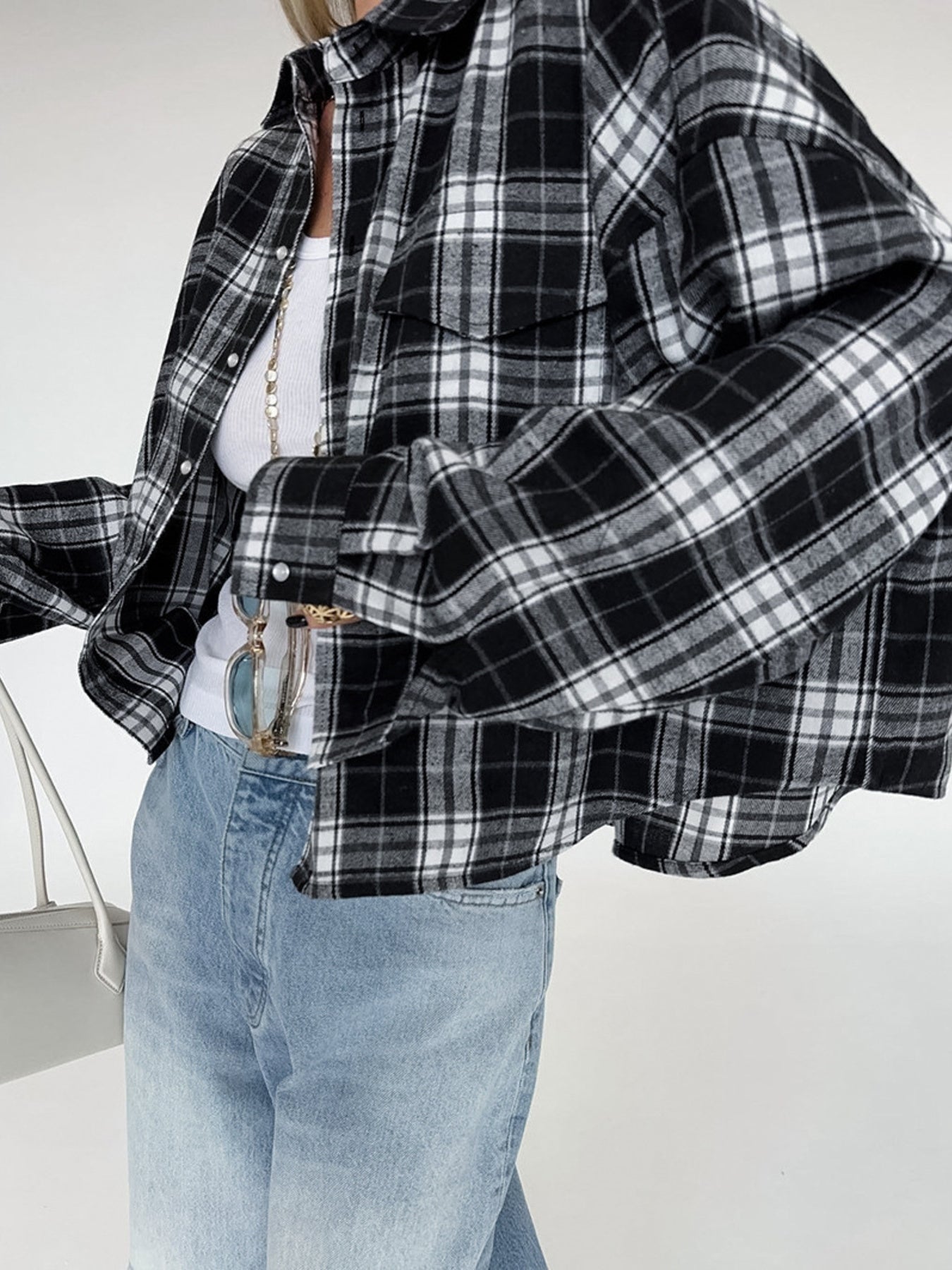 Oversized black and white plaid cotton button-up shirt with collar and chest pockets.