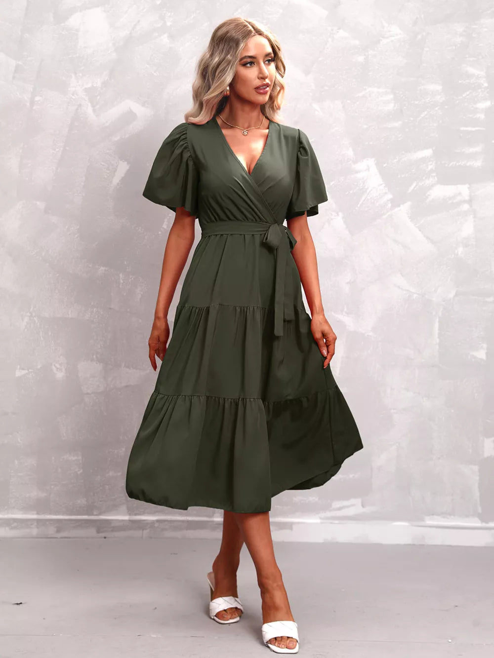 Dark green tiered midi dress with flutter sleeves and a belted waist