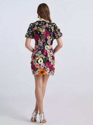Black floral embroidered mini dress with puff sleeves and applique flowers.