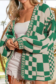 Green and beige checkered acrylic cardigan with balloon sleeves and open front.