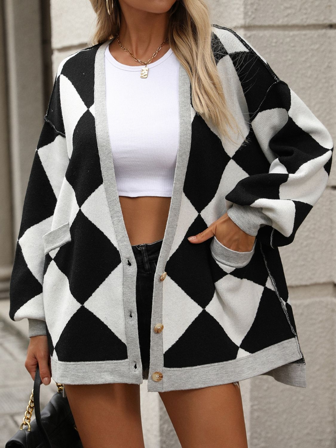 Argyle knit oversized cardigan in black and ivory with grey trim and pockets.