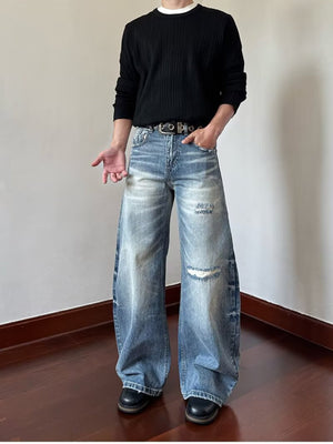 Men's distressed blue wide-leg jeans with ripped details, made of cotton.