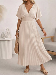 Elegant apricot pleated midi dress with v-neck and smocked waist, short sleeves.