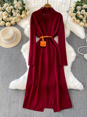 Burgundy knitted maxi dress and cardigan ensemble with a belted waist and mini pouch.