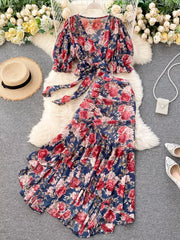 Chic floral two-piece crop set in dark blue with pink and red flowers, featuring a tie-front top and ruffled skirt.