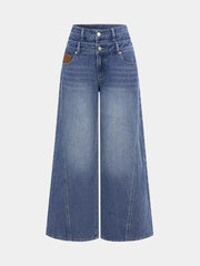 Chic high-waisted wide-leg jeans in blue denim with button closure and a brown leather patch detail.