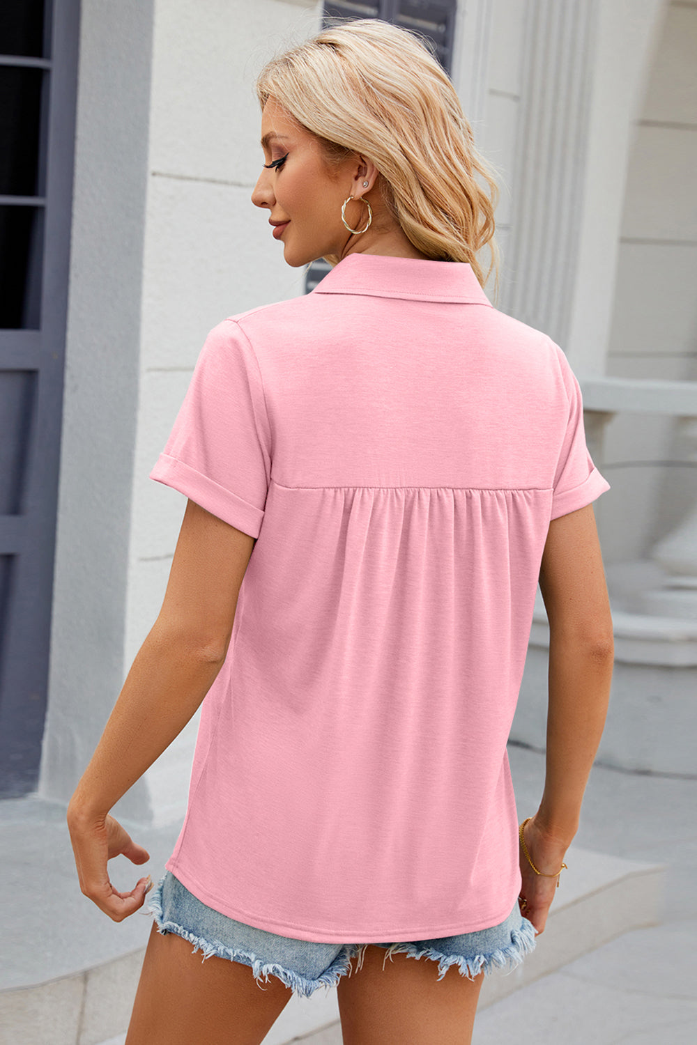 Blush pink polo top with short sleeves and gathered yoke detail.