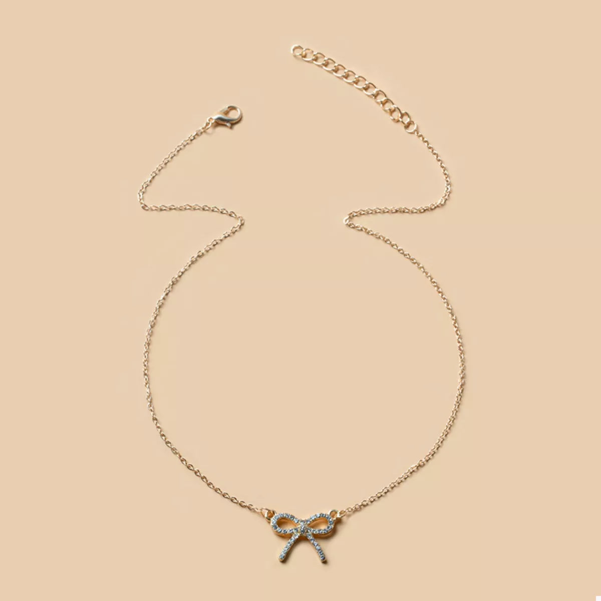 Gold bowknot pendant necklace with clear crystals on a delicate chain