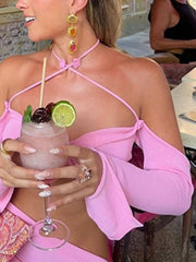 Pink halter neck knit set with flower detail and long sleeves, styled with jewelry.