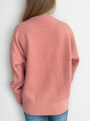 Oversized crewneck knit pullover sweater in Burnt Coral, with ribbed cuffs and hem.