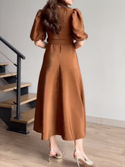 Belted midi dress in brown with puff sleeves and a-line skirt.