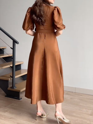 Belted midi dress in brown with puff sleeves and a-line skirt.