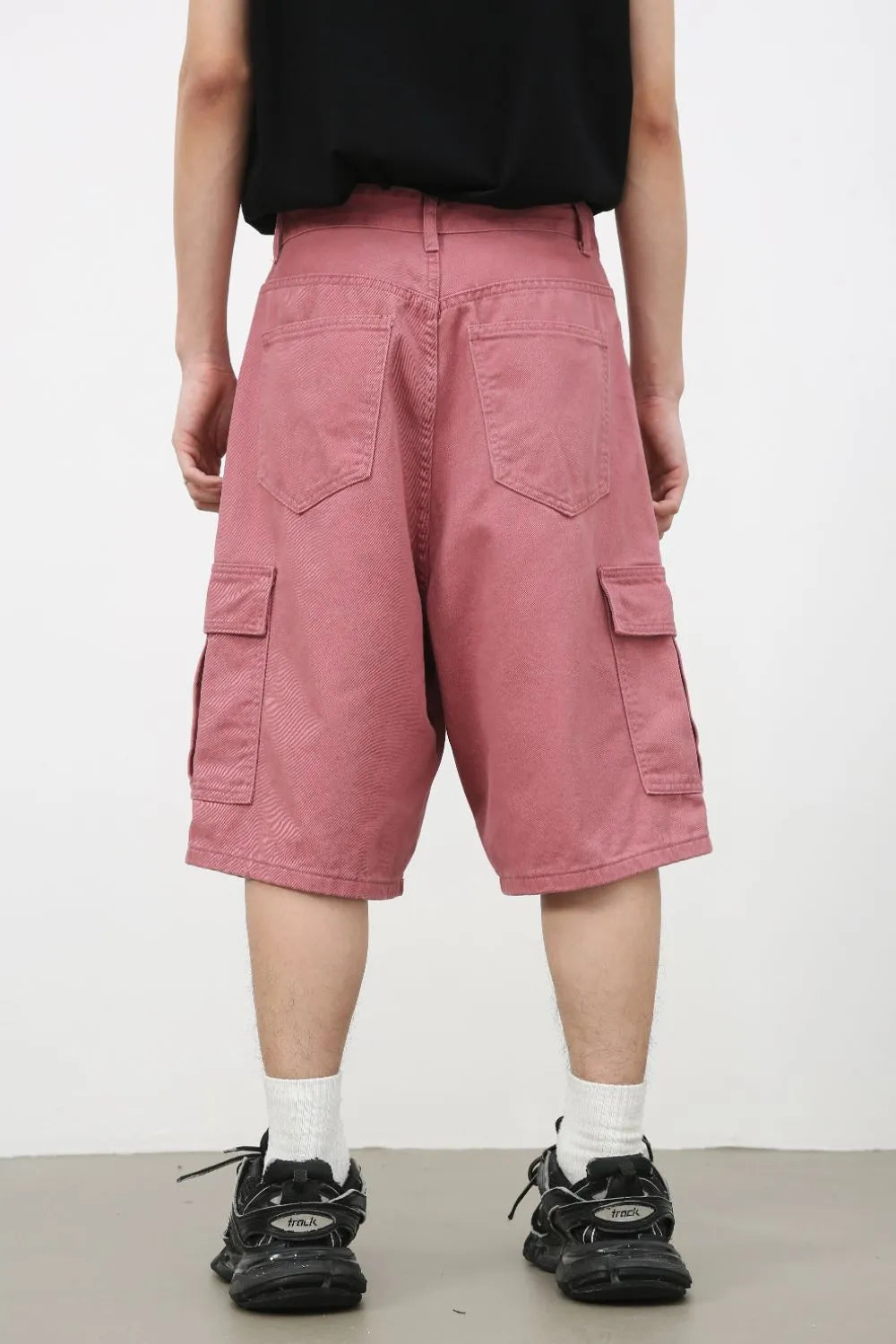 Magenta baggy cargo bermuda shorts with textured fabric and multiple pockets.