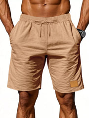 Light Khaki chino shorts with drawstring waist and side pockets, featuring a small patch detail.