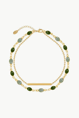 Dual chain bracelet in gold with green and grey oval stones and a gold bar accent