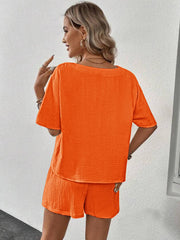 Orange textured gauze lounge set with short sleeves and shorts.