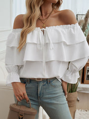 White tiered ruffle off-shoulder blouse with tie neck and ruffled cuffs.