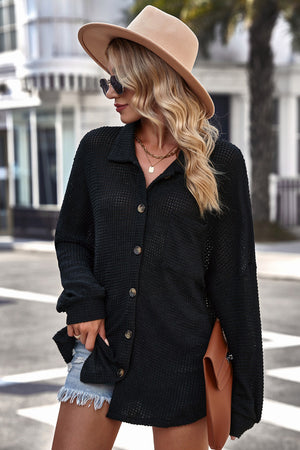Black waffle-knit oversized shirt jacket with button front and collar, styled with denim shorts.
