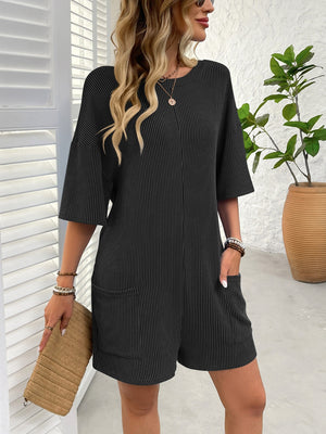 Black ribbed knit romper with short sleeves and two front pockets.