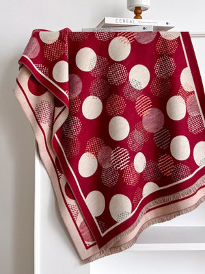 Deep red scarf with textured polka dots and fringed edges.