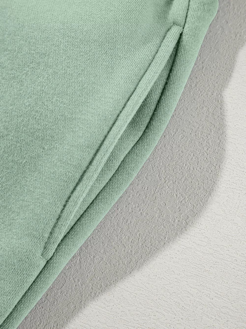 Sage cotton joggers with a side pocket detail.