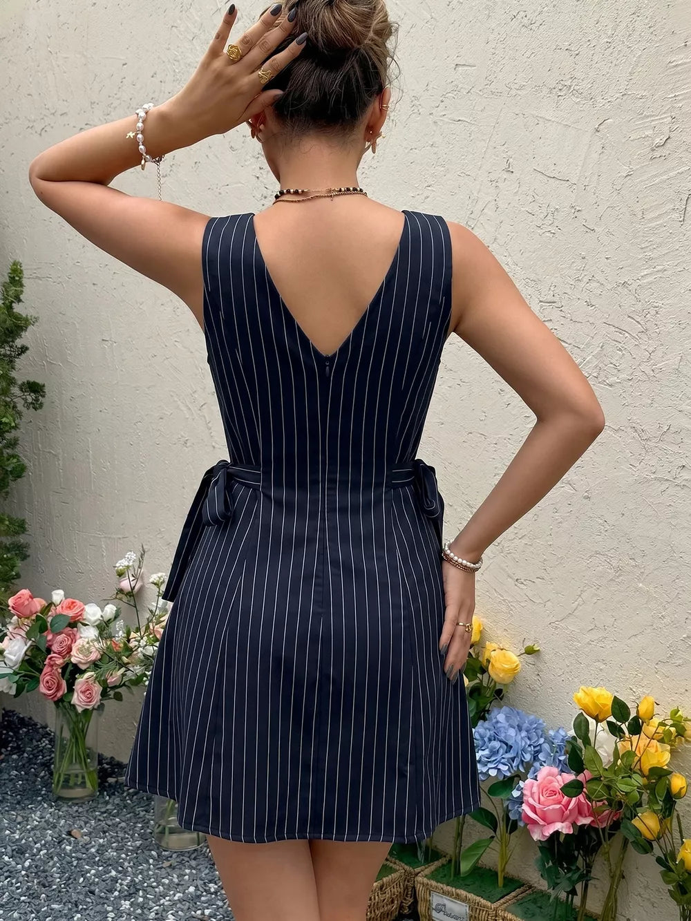 Navy striped tie-waist a-line dress with V-neck and sleeveless design.