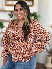 Caramel print blouse with ruffle front and balloon sleeves.