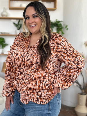 Caramel print blouse with ruffle front and balloon sleeves.