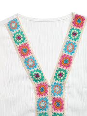 White V-neck blouse with colorful crochet trim and button detail