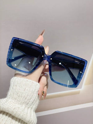 Oversized square blue gradient sunglasses with a striped frame detail.