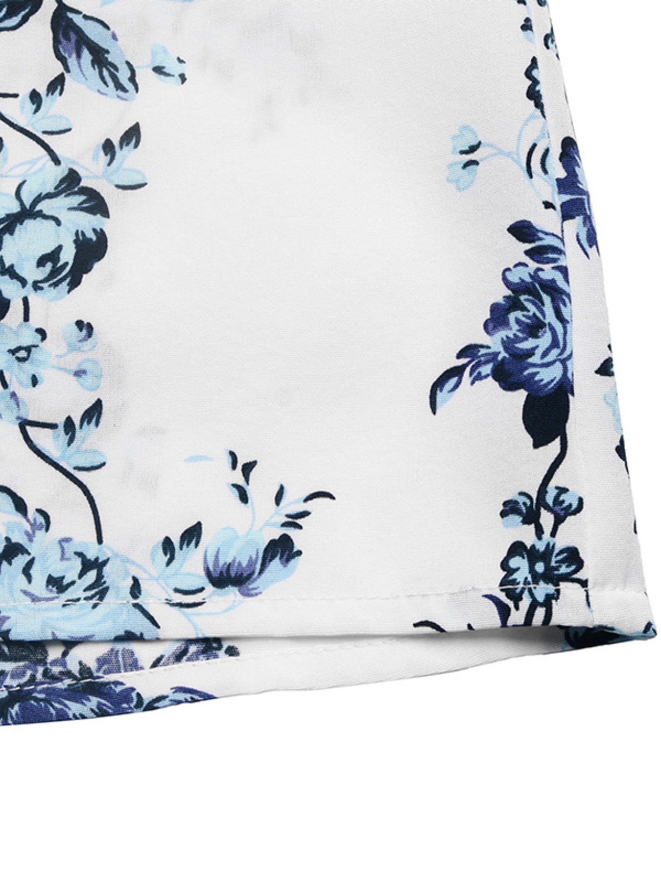 White romper with blue floral print, showing fabric detail and hem.