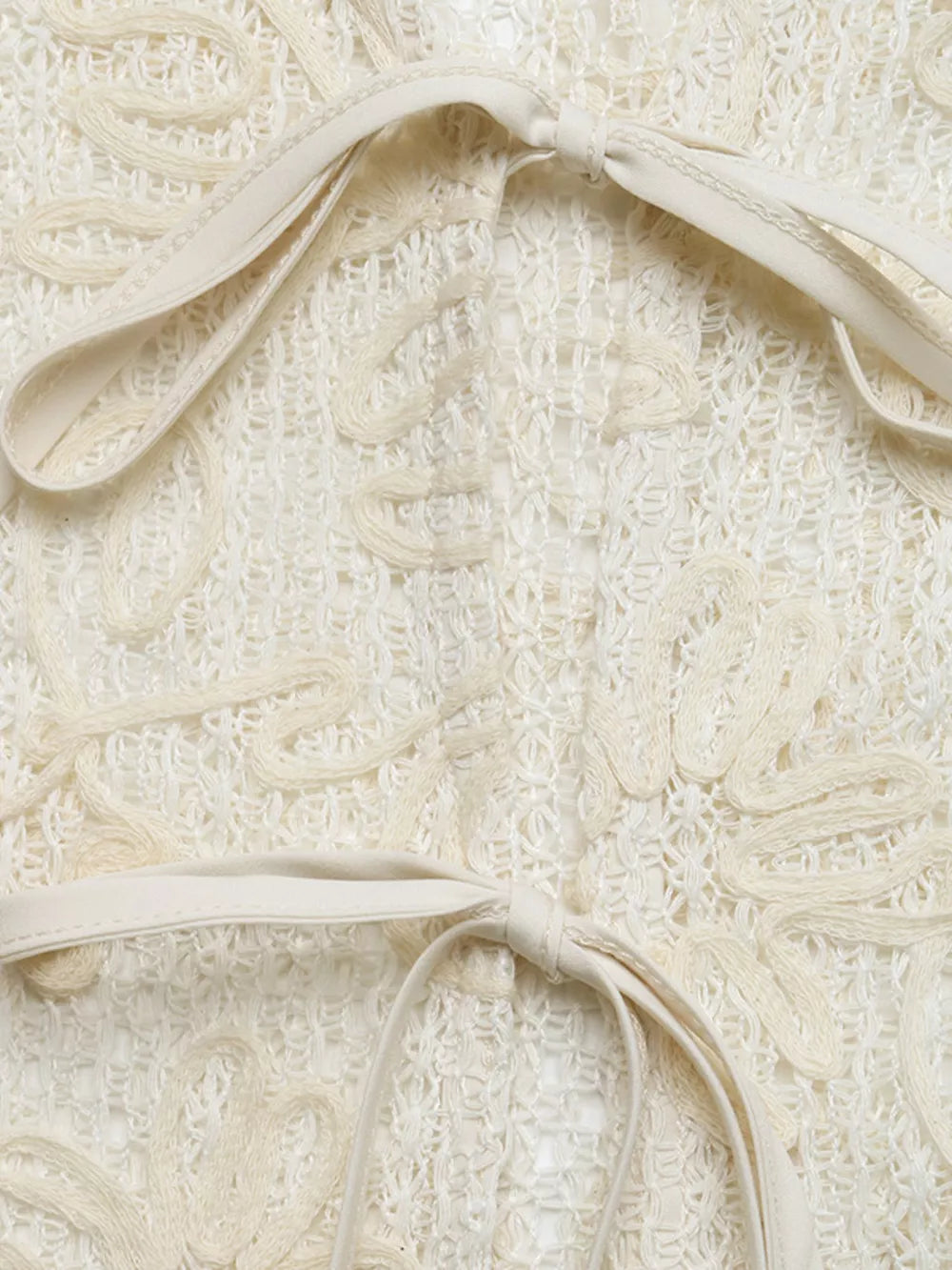 Delicate floral lace tie-front shirt in ivory with cutout details and ribbon ties.
